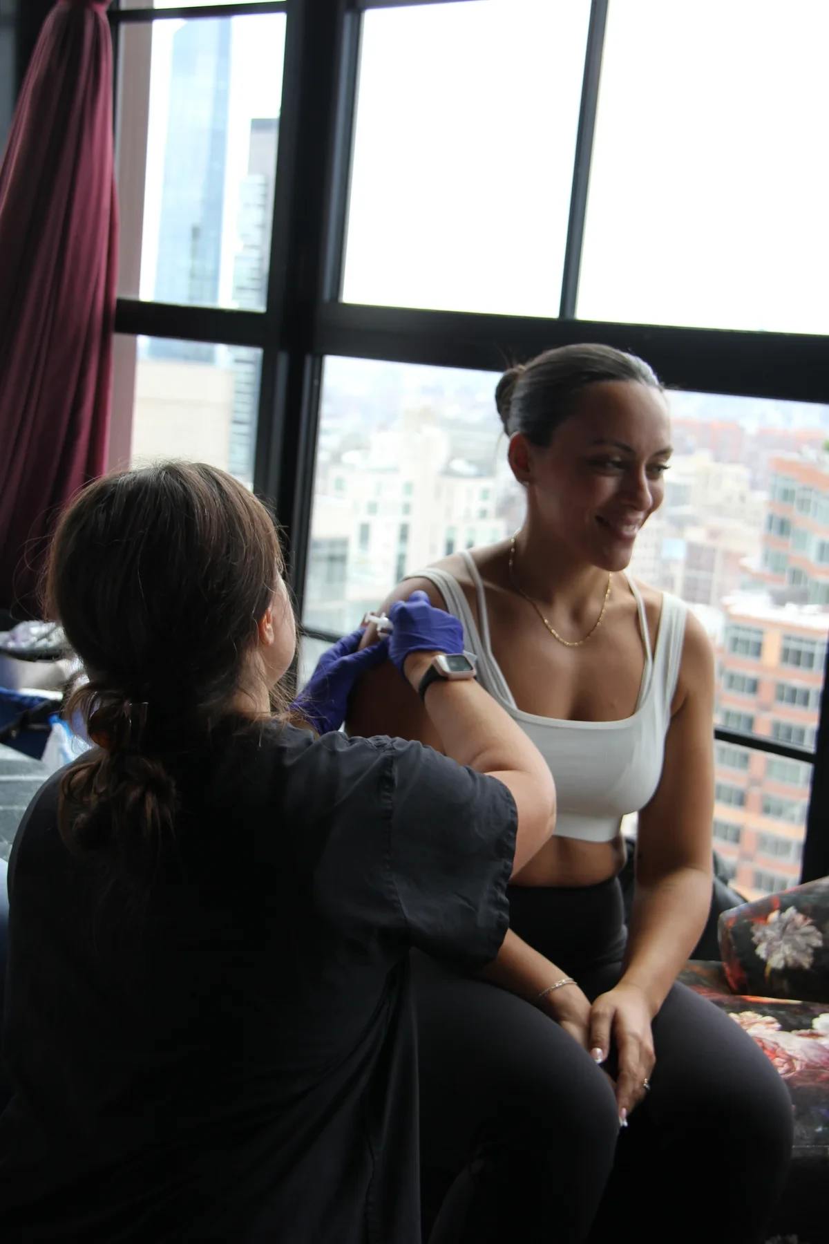 Drip Lounge clinician with a client during a private mobile IV visit in a New York City apartment