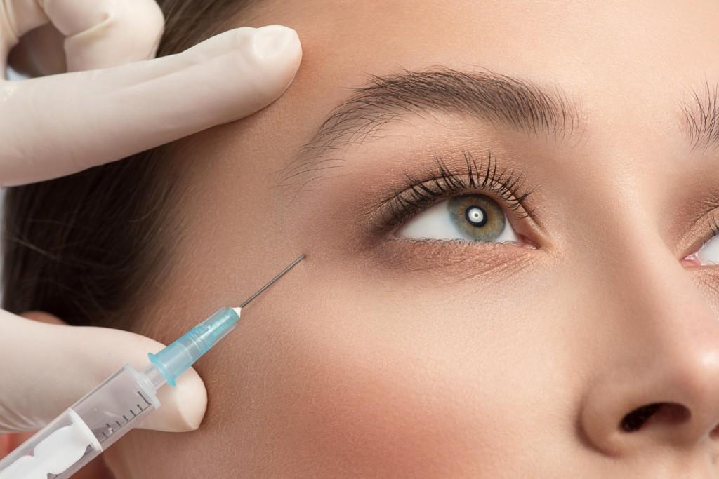 Close-up of a careful Botox injection near the outer eye area